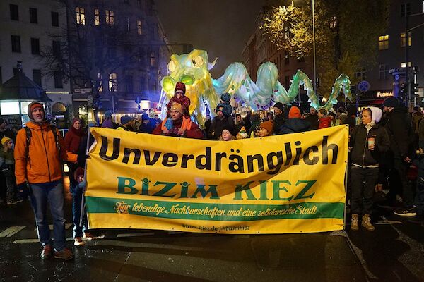 Foto: © heba / Umbruch Bildarchiv Das Foto von © heba zeigt den erleuchteten Kiezdrachen hinter dem Bizim Kiez Transparent