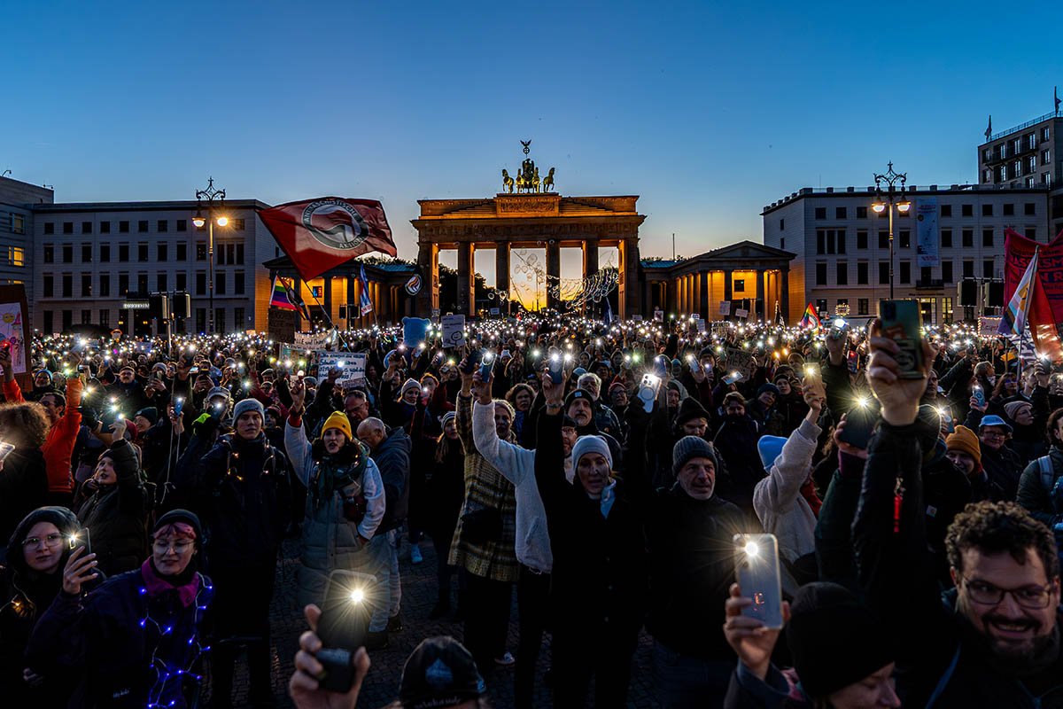 Das Foto zeigt zahlreiche Demonstrant:Innen vor dem Brandenburger Tor mit eingeschalteten Handytaschenlampen