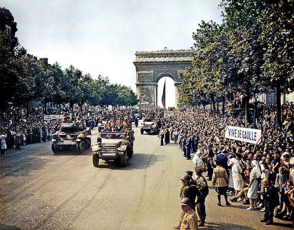 Menschenmengen säumen die Champs Elysees, um am 26. August 1944, nach der Befreiung von Paris, die Panzer der Freien Franzosen und die Halbkettenfahrzeuge der 2e DB von Leclerc durch den Triumphbogen fahren zu sehen. Menschenmengen säumen die Champs Elysees, um am 26. August 1944, nach der Befreiung von Paris, die Panzer der Freien Franzosen und die Halbkettenfahrzeuge der 2e DB von Leclerc durch den Triumphbogen fahren zu sehen.