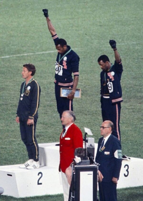 Die Siegerehrung im 200-Meter-Lauf 1968: links Peter Norman (Silber), Mitte Tommie Smith (Gold), rechts John Carlos (Bronze) Foto: Angelo Cozzi (Mondadori Publishers), Public domain, via Wikimedia Commons Die Siegerehrung im 200-Meter-Lauf 1968: links Peter Norman (Silber), Mitte Tommie Smith (Gold), rechts John Carlos (Bronze) Foto: Angelo Cozzi (Mondadori Publishers), Public domain, via Wikimedia Commons