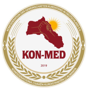 Das Logo zeigt die Region Kurdistan, dahinter die gelbe Sonne darunter KON-MED und die Jahreszahl 2019. Das Logo ist umrahmt von Ähren.