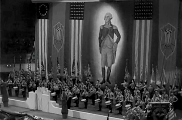New Yorker Veranstaltung im Madison Square Garden (1939) Das Foto zeigt die Bühne mit den überlebensgroßen Bild George Washingtons, U.S. Fahnen sowie dem Logo des Amerikadeutschen Volksbundes Hinter dem Rednerpodest stehen Fahnenträger und Trommler in typischer SA Uniform New Yorker Veranstaltung im Madison Square Garden (1939) Das Foto zeigt die Bühne mit den überlebensgroßen Bild George Washingtons, U.S. Fahnen sowie dem Logo des Amerikadeutschen Volksbundes Hinter dem Rednerpodest stehen Fahnenträger und Trommler in typischer SA Uniform