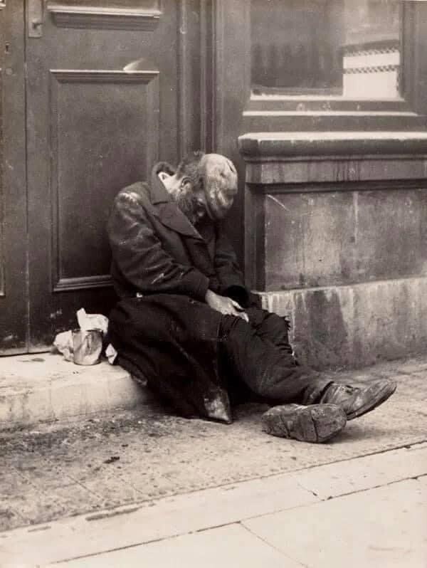 Homeless Man, early 1900s. Photo by William Whiffin. A presumed homeless person is lying in a gateway. Early 1900s. Photo by William Whiffin.